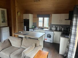 A kitchen with a washing machine and refrigerator at Pet Friendly - Lodge at Riverview Holiday Park, Mangerton near Newcastleton