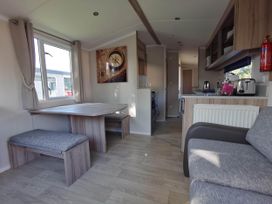 A living room with a table and benches at 8Berth- SmartTV- CloseToBeach- FamilyFriendly Mablethorpe