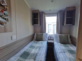 A bedroom with twin beds and shelves at 8Berth- SmartTV- CloseToBeach- FamilyFriendly, Mablethorpe