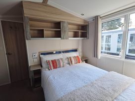 A bedroom with a bed and shelves at 8Berth- SmartTV- CloseToBeach- FamilyFriendly in Mablethorpe