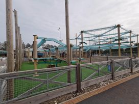 An outdoor play area with climbing structures and safety barriers at 8Berth- SmartTV- CloseToBeach- FamilyFriendly in Mablethorpe