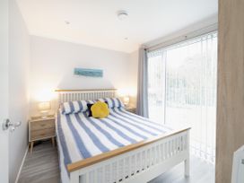 A bedroom with a bed and bedside table at 8Berth- SmartTV- CloseToBeach- FamilyFriendly in Millendreath near Looe