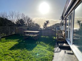 A garden with a table and bench at 8Berth- SmartTV- CloseToBeach- FamilyFriendly in Millendreath near Looe