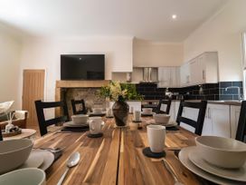 A dining area with a wooden table and chairs at Foundry Farm Apartment 
