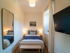 A bedroom with a bed, television, and mirror at Foundry Farm Apartment