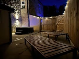 An outdoor area with a hot tub and deck chairs at Foundry Farm Apartment