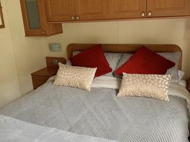 A bedroom with a bed and pillows at Static Caravan 2 Bedrooms - sleeps 4 in Hawick