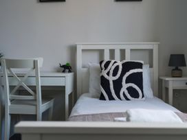 A bedroom with a bed, desk, chair, and lamp at Lily Apartment - Sleeps 3 - Pet friendly - Parking, Bedlington