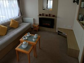 A living room with a sofa, coffee table, and tea set at 3 Bed, Sleeps 6, Parking