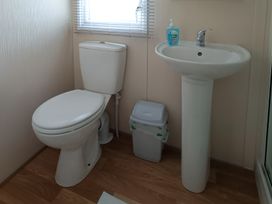 A bathroom with a toilet and sink at 3 Bed, Sleeps 6, Parking