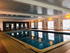 An indoor pool with large windows and lighting at 3 Bed, Sleeps 6, Parking