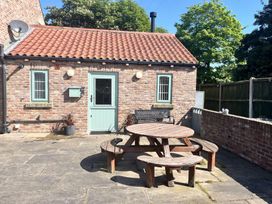 An outdoor area with a round table and chairs at TBC