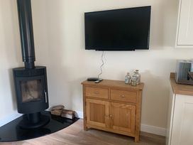 A living room with a wood stove and a television at TBC