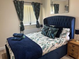 A bedroom with a bed and bedside table at TBC