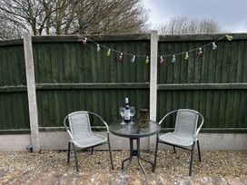 An outdoor seating area with a table and chairs at TBC in 