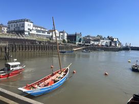 A view of boats on water with buildings and a pier at TBC 