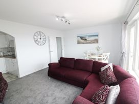 A living room with a sofa and dining area at The Cartwheel in Amroth