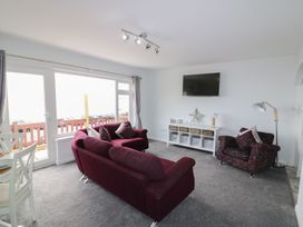 A living room with a sofa and an armchair at The Cartwheel in Amroth