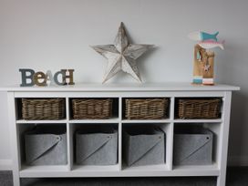 A shelf with woven baskets and decorative items at The Cartwheel in Amroth