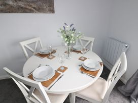 A dining room with a round table set for four at The Cartwheel in Amroth