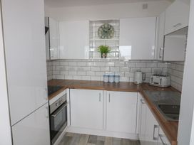 A kitchen with cabinets, oven, sink, kettle and toaster at The Cartwheel in Amroth