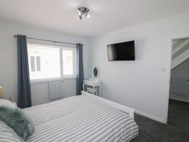 A bedroom with a bed and television at The Cartwheel in Amroth