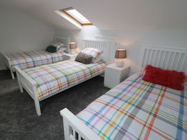 A bedroom with three beds and lamps at The Cartwheel in Amroth