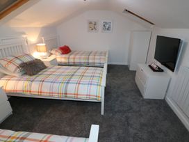 A bedroom with two single beds and a television at The Cartwheel in Amroth