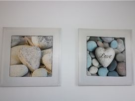 Framed art featuring heart-shaped stones at The Cartwheel in Amroth
