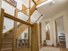 A hallway with a staircase and a mirror at 6 Knowle Court Salcombe