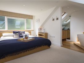 A bedroom with a bed and ensuite bathroom at 6 Knowle Court Salcombe