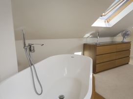 A bathroom with a bathtub and a dresser at 6 Knowle Court in Salcombe