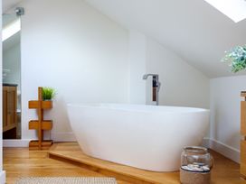 A bathroom with a bathtub and wooden elements at 6 Knowle Court in Salcombe