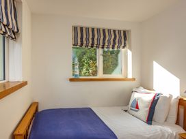 A bedroom with a bed and window in 6 Knowle Court in Salcombe