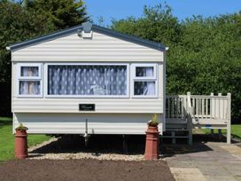 A mobile home with a deck and planters at 84 Sandhills in Ingoldmells