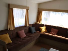 A living room with a sofa and cushions at 84 Sandhills in Ingoldmells