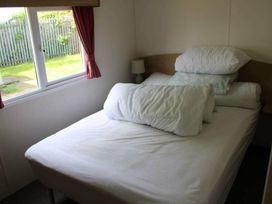 A bedroom with a bed and a lamp at 84 Sandhills in Ingoldmells