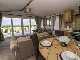 A living room with dining table and sofa at The Dorchester at Bay View in New Quay