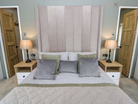 A bedroom with a bed and lamps at The Dorchester at Bay View New Quay