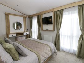 A bedroom with a bed and a desk at The Dorchester at Bay View in New Quay