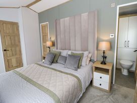 A bedroom with a bed and bedside table at The Dorchester at Bay View New Quay