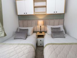 A bedroom with two beds and a lamp at The Dorchester at Bay View New Quay