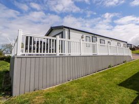 A house with a deck and railing at The Dorchester at Bay View New Quay