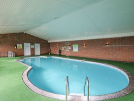 An indoor swimming pool with steps at The Dorchester at Bay View near Maen-y-groes