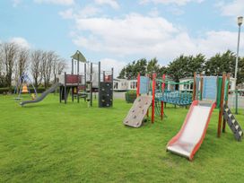 A playground with slides and climbing structures at The Dorchester at Bay View in Maen-y-groes near New Quay