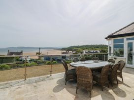 An outdoor dining area with a table and chairs overlooking the sea at Hillside