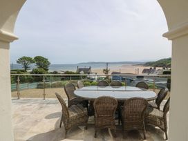 An outdoor terrace with a table and chairs overlooking the sea at Hillside