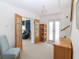 A hallway with a chair and a display cabinet at Hillside 