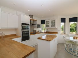 A kitchen with countertops, appliances, and a dining table at Hillside