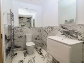 A bathroom with a toilet, sink, and mirror at Hillside
